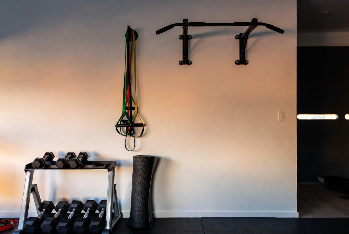 Organized home gym corner with dumbbells resistance bands yoga mat