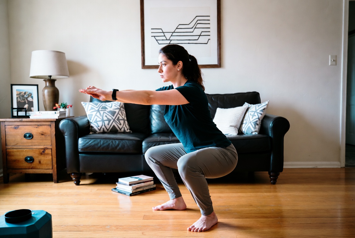 Person doing bodyweight squats in living room