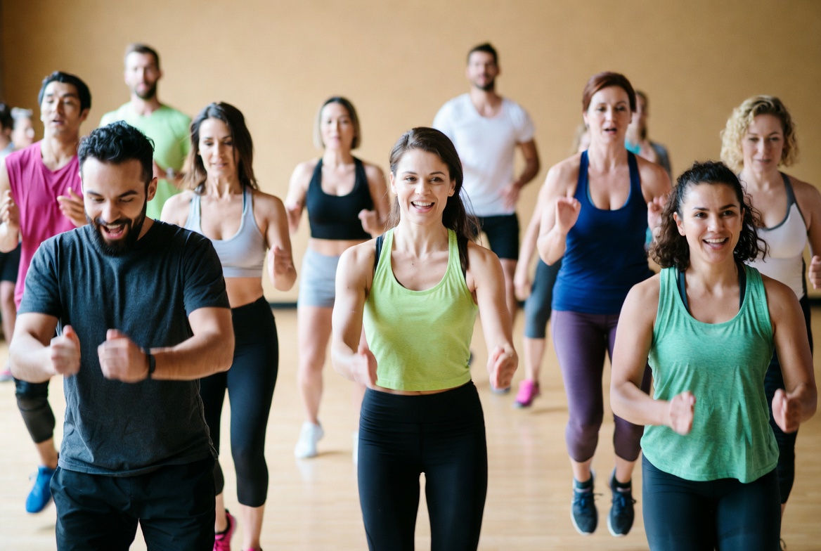 Diverse group fitness class mid-workout with energy