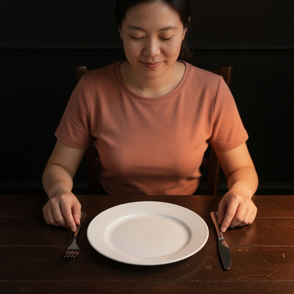 Person sitting peacefully with empty plate in meditation